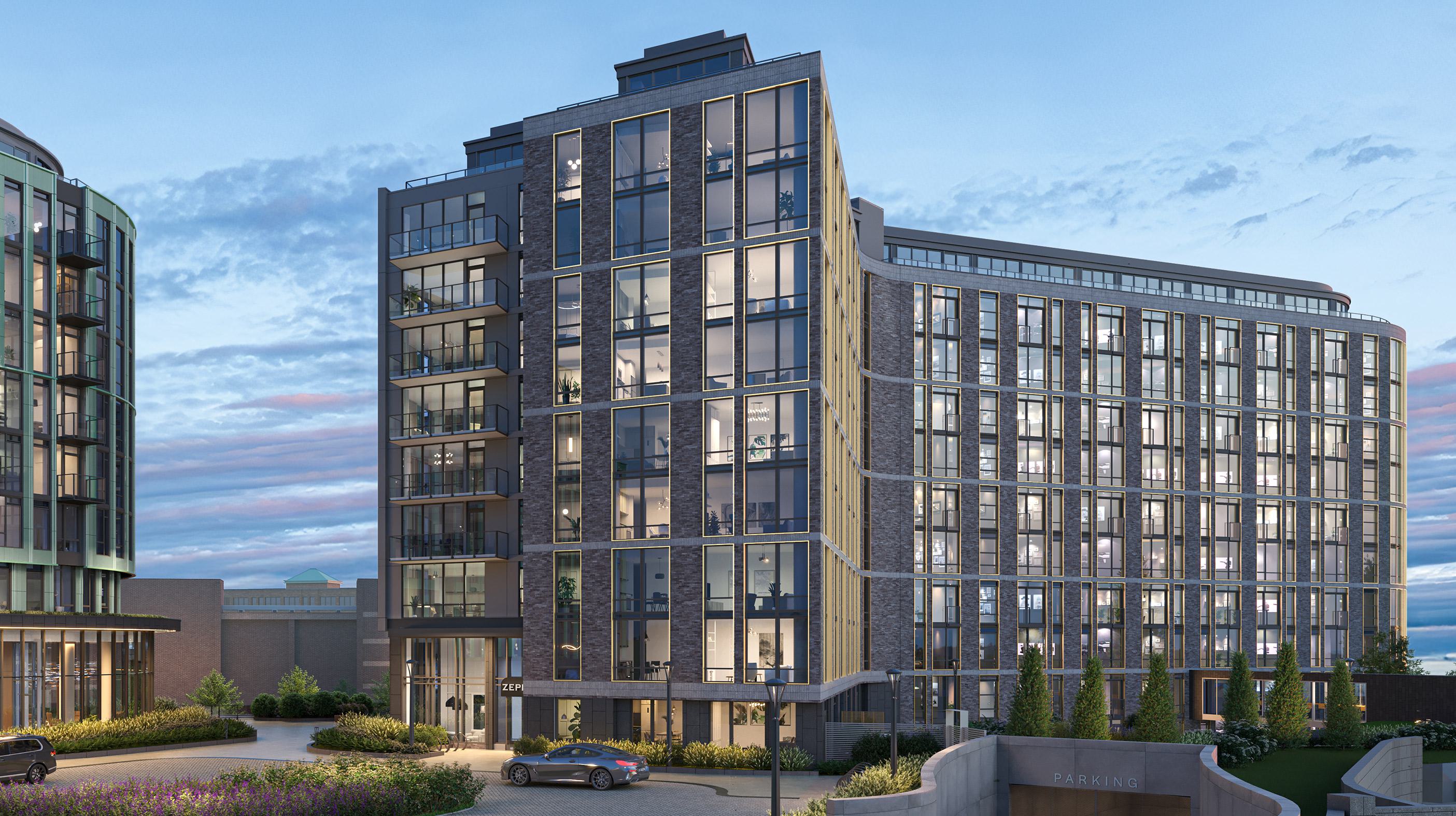 Street-level view of Zephyr’s modern exterior at dusk, showcasing its sleek glass façade, clean architectural lines, and softly lit interiors with landscaped surroundings.
