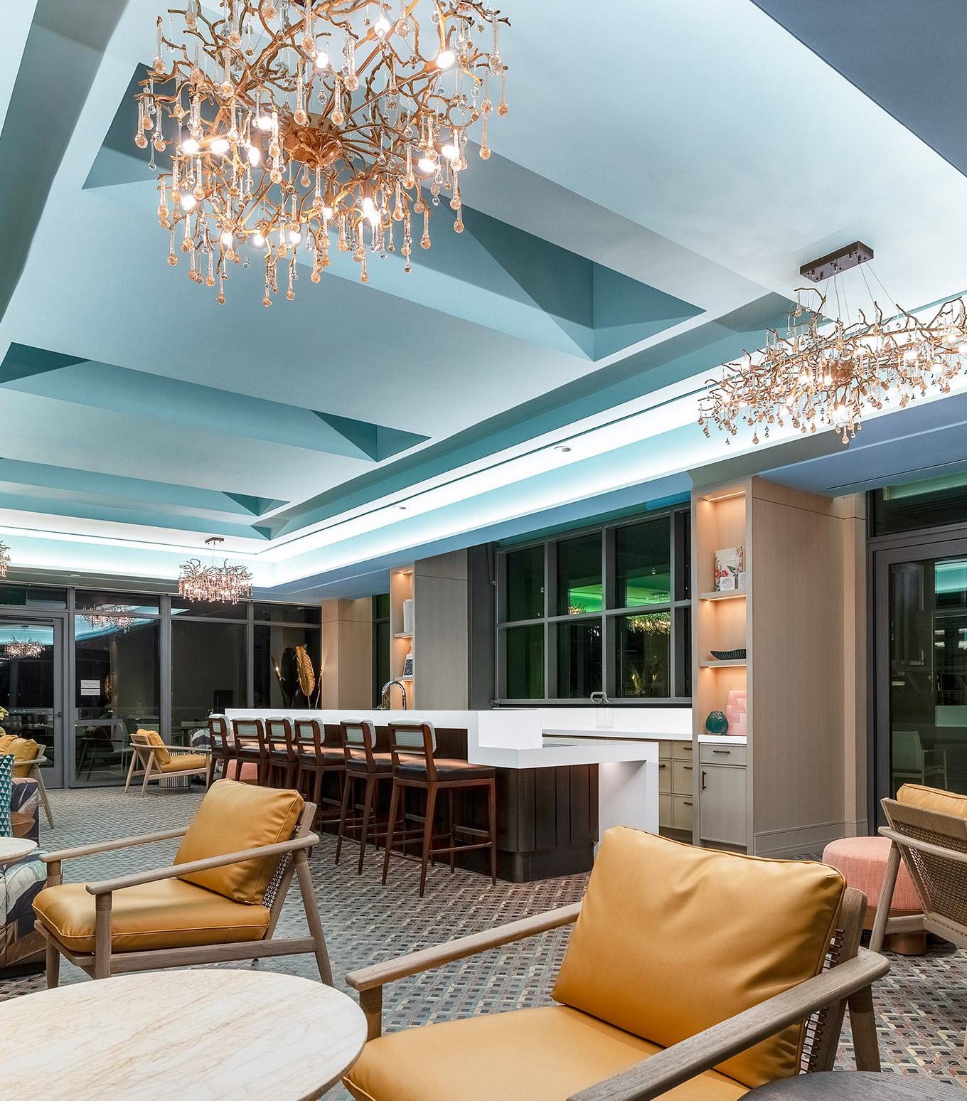 resort-style outdoor pool surrounded by lounge chairs and umbrellas, set within a landscaped courtyard of Aerie modern glass-and-metal residential building.