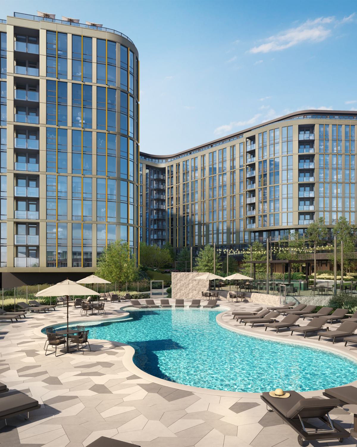 resort-style outdoor pool surrounded by lounge chairs and umbrellas, set within a landscaped courtyard of Aerie modern glass-and-metal residential building.