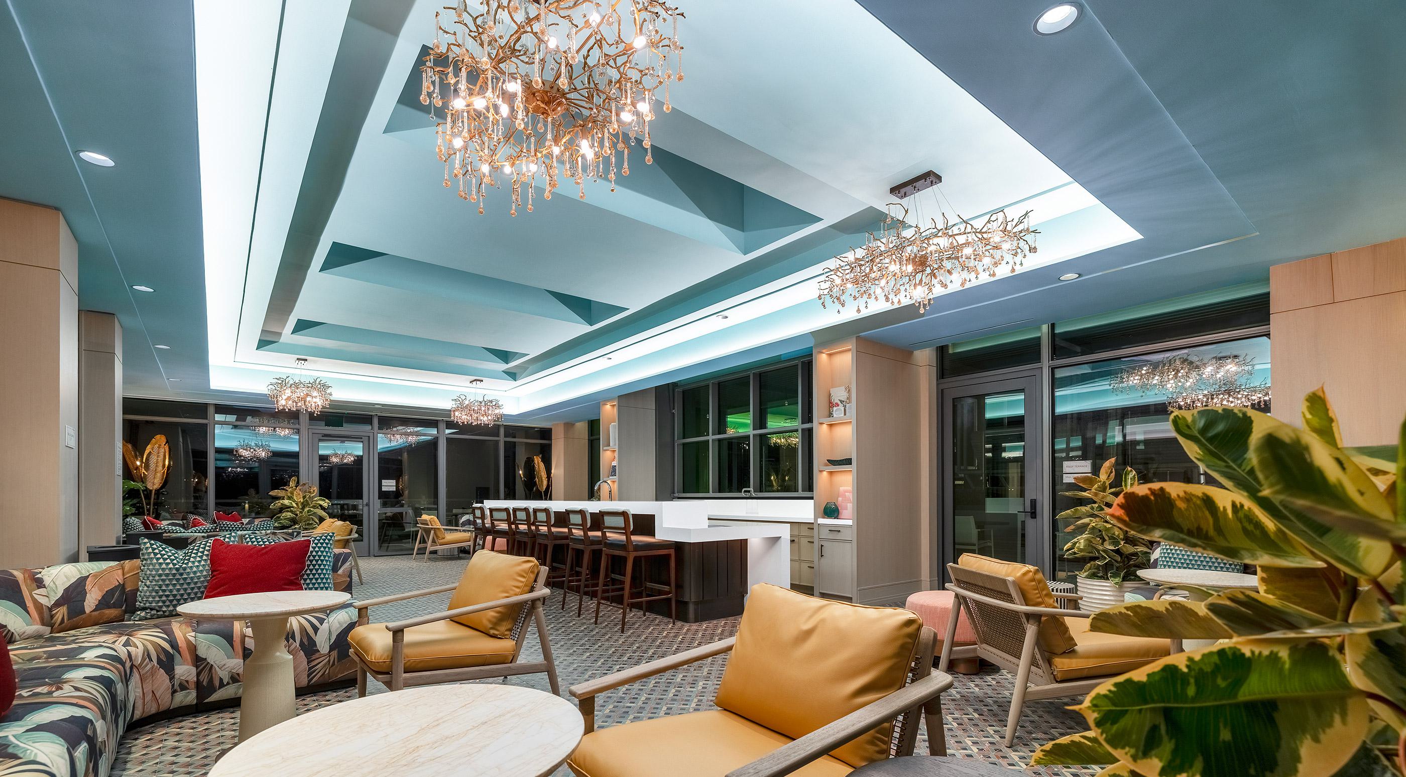 resort-style outdoor pool surrounded by lounge chairs and umbrellas, set within a landscaped courtyard of Aerie modern glass-and-metal residential building.