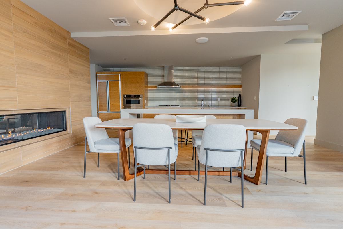 Modern community clubhouse at The Triton Apartments featuring a spacious lounge with contemporary seating, workstations, large windows for natural light, and stylish decor.