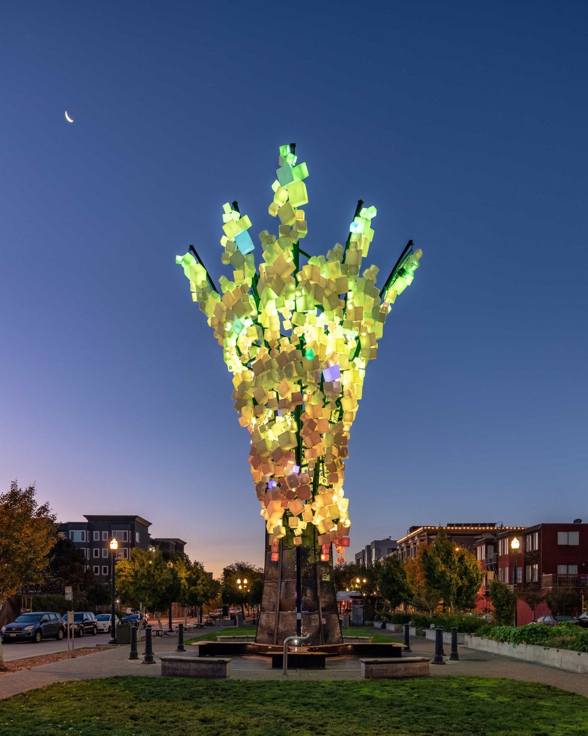 Glowing LED sculpture "Paige’s Tree" lights up the night at Patricia’s Green in Hayes Valley, San Francisco, with vibrant green and yellow cubes reaching skyward.