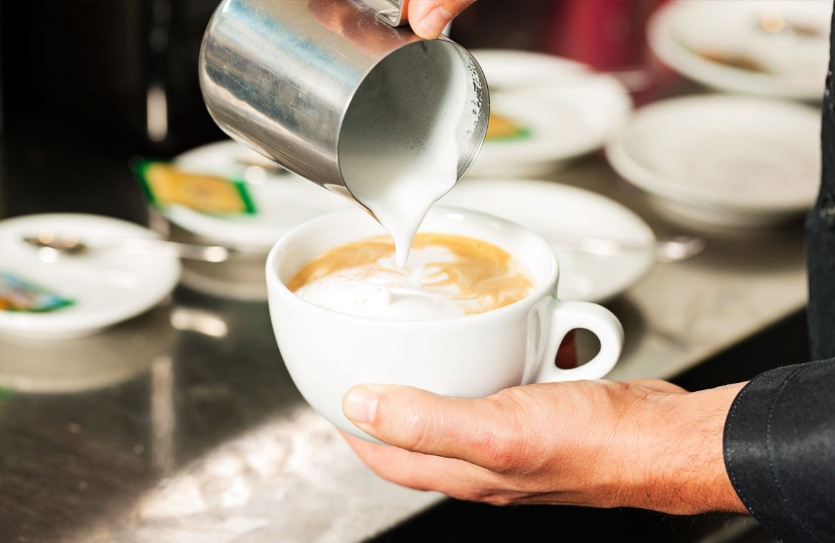 barista making a latte at a coffee shop - The Madrid Westchester LA Neighborhood