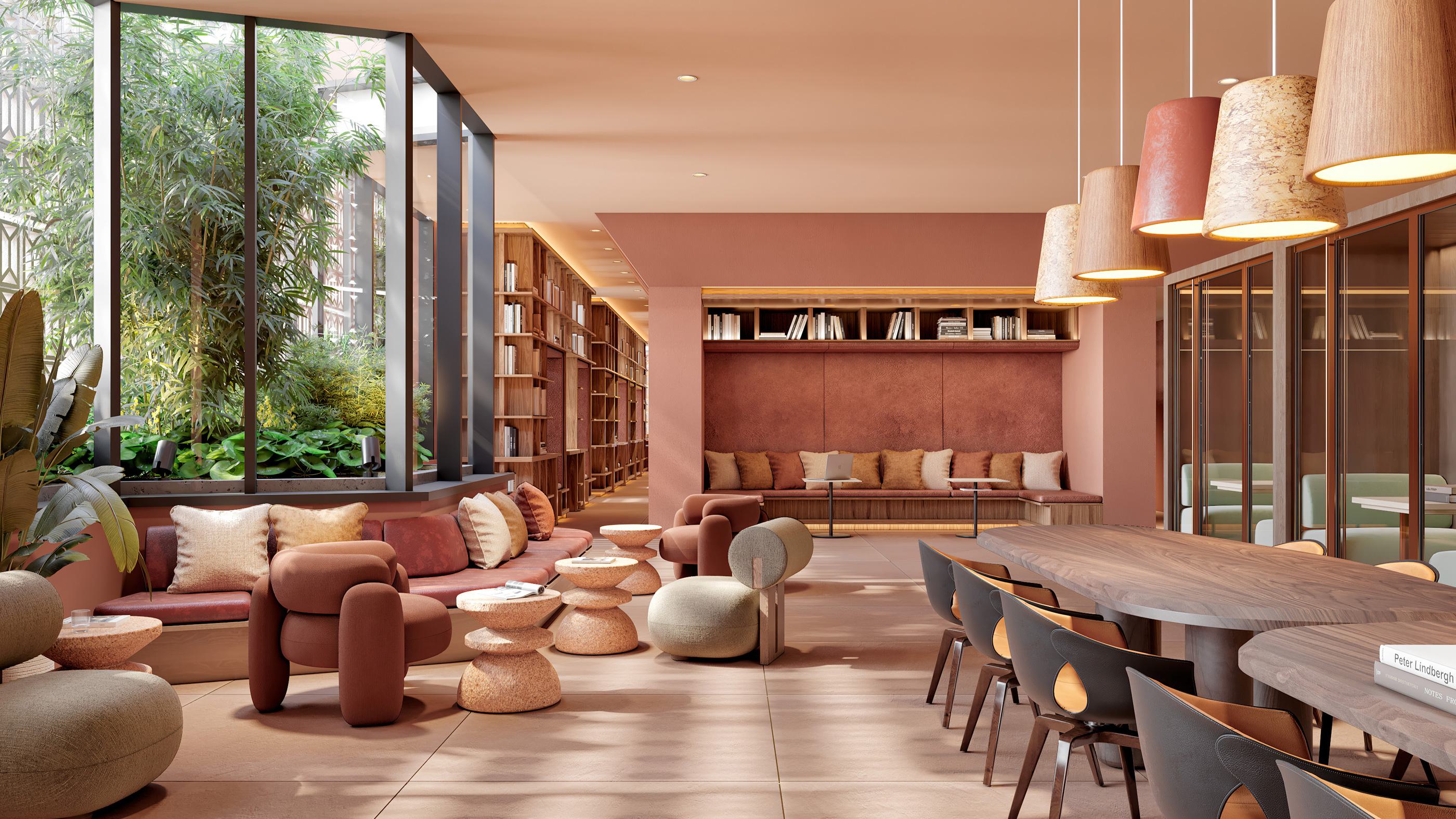 Co-working lounge with earthy tones, cozy seating, expansive bookshelves, large shared tables, and lush greenery visible through oversized windows.