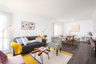 colorful townhome apartment with bright, white walls, large windows, and mid century furnishings