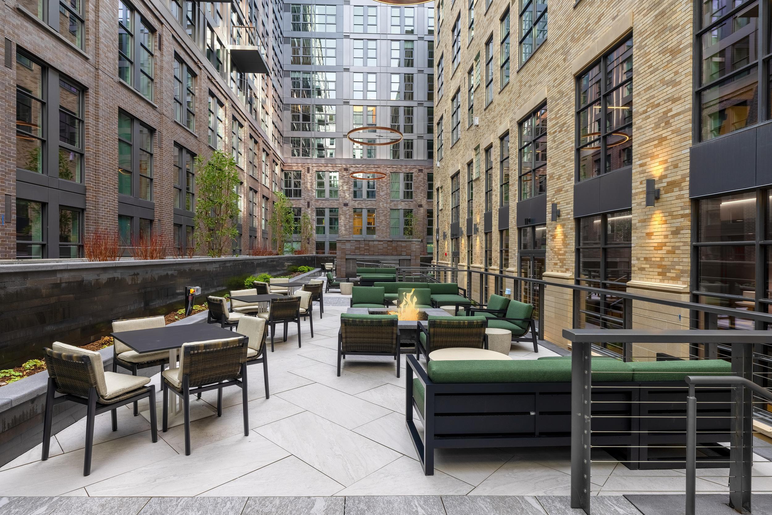 Open-air courtyard at Annex on 12th with modern lounge seating, fire pits, and brick walls surrounding the historic building.