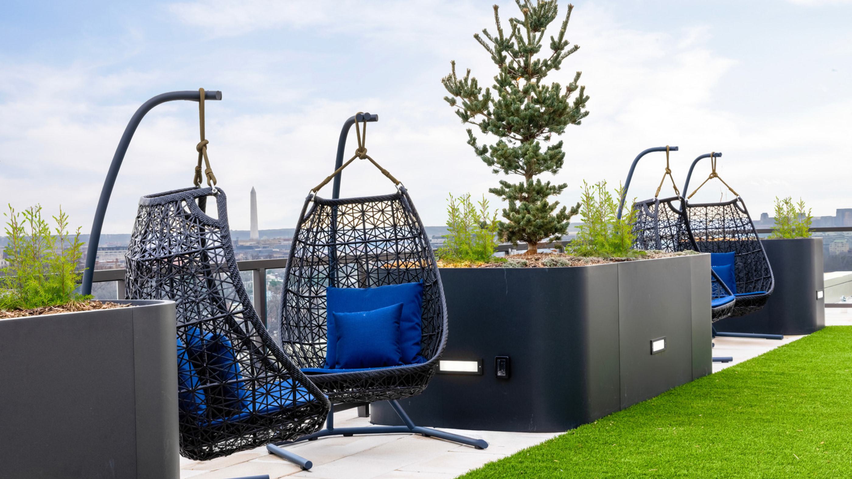 Two hanging chairs on a rooftop with a view.