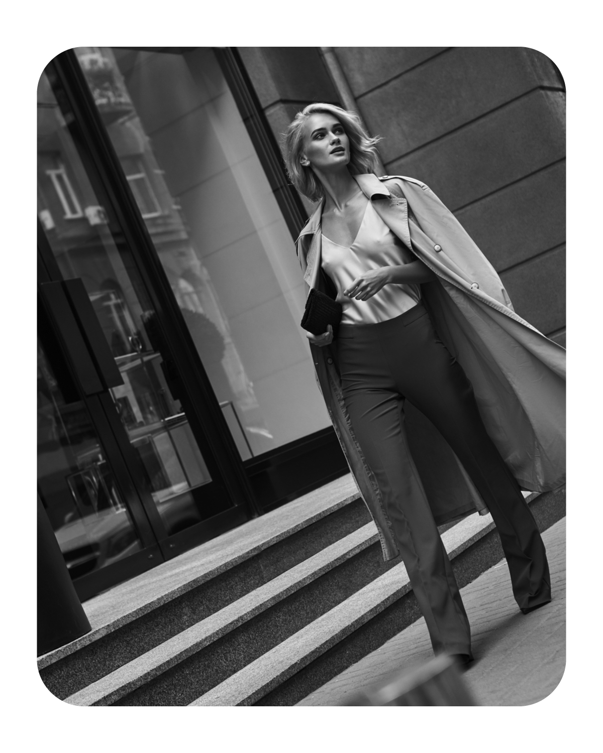 Stylish woman walking confidently in the city wearing a trench coat.