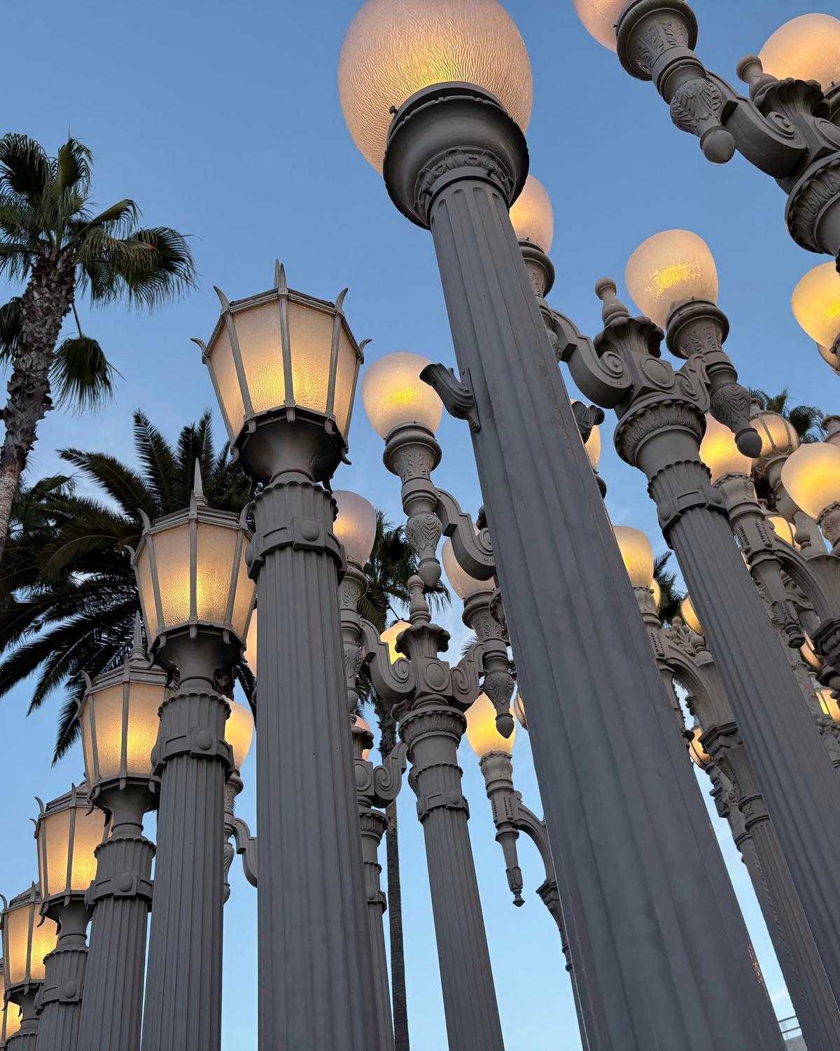 Iconic “Urban Light” installation at LACMA in Miracle Mile, featuring rows of glowing vintage street lamps at dusk.