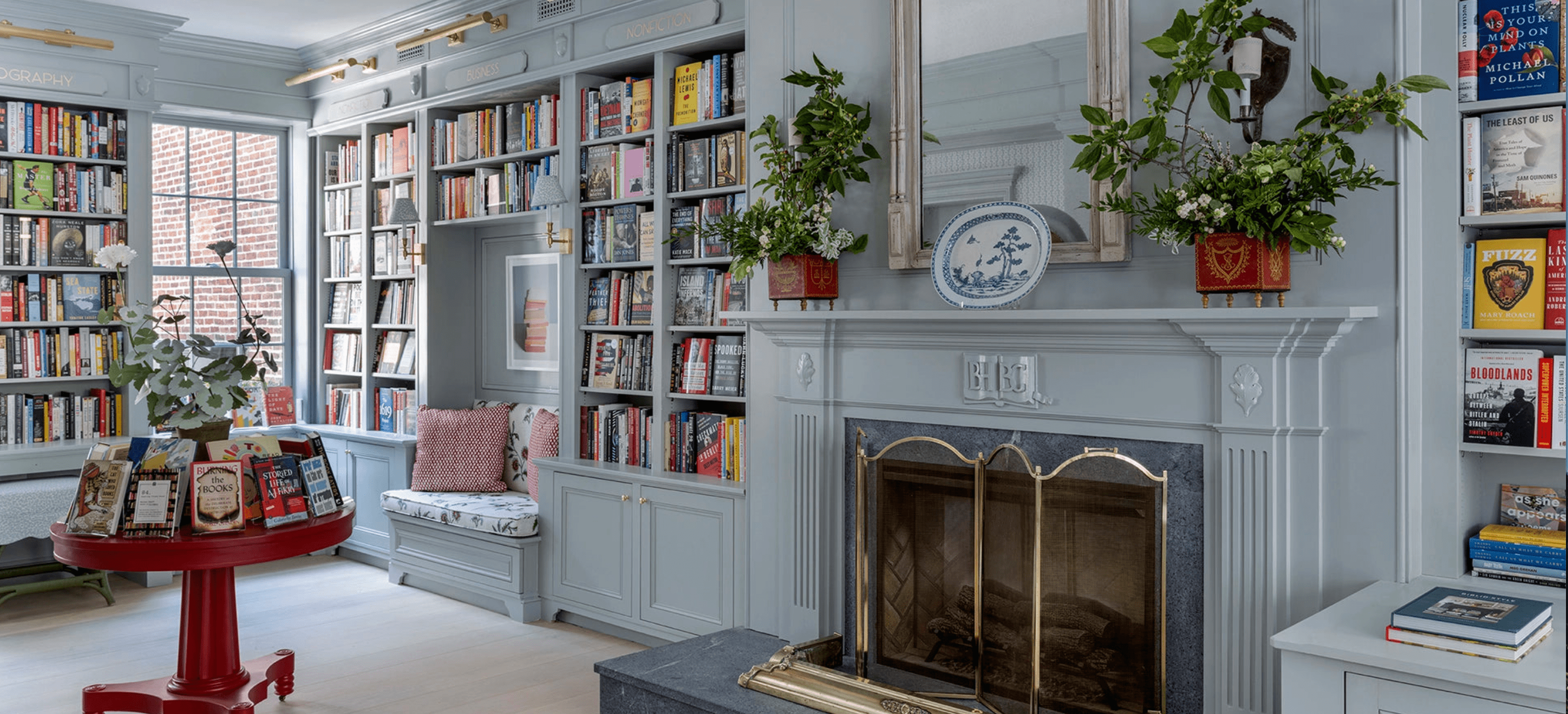 interior of Beacon Hill Books & Café in Boston. The space has a warm, elegant design with light blue built-in bookshelves filled with colorful titles