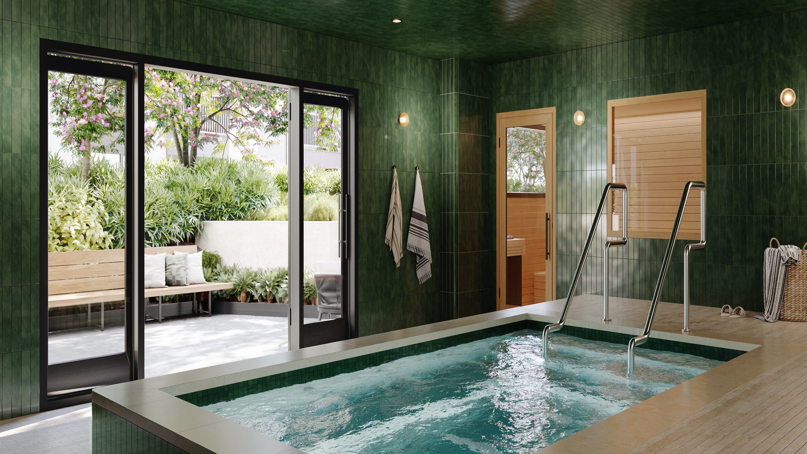 Indoor spa at Revery with green tile walls, heated pool, and adjacent wood-lined sauna opening to a landscaped courtyard.