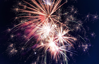 Huge pink and white fireworks in the night sky