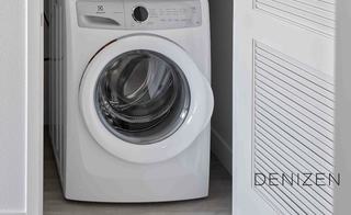 In-unit stacked Electrolux washer and dryer set in a white closet space at Denizen, offering convenient, modern laundry access for residents.