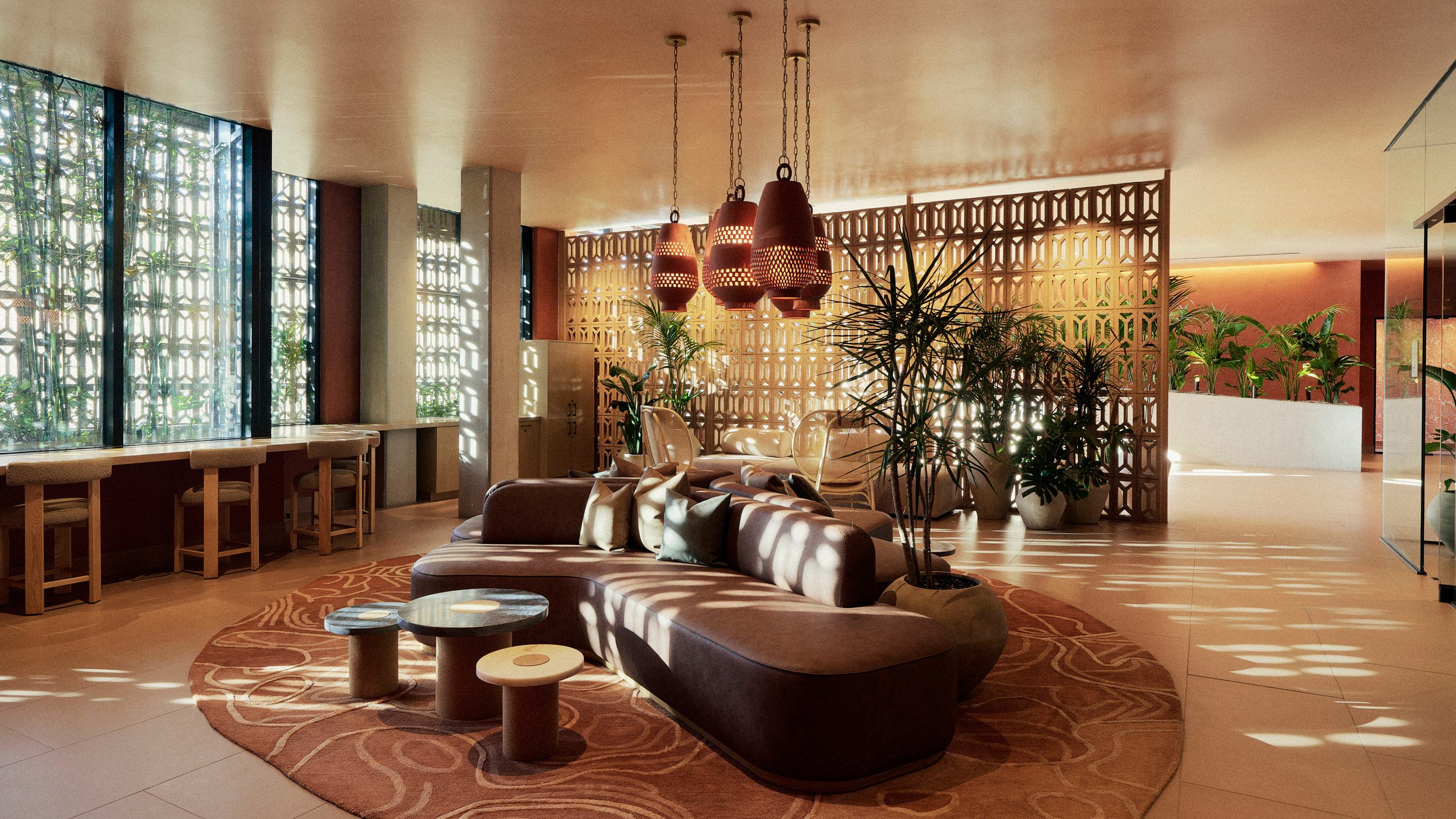 Rooftop lounge at Rowyn in Hillcrest, San Diego, with a modern suspended fireplace, deep green velvet sectional seating, and a long rustic wood dining table set for twelve. Overhead, sculptural pendant lights in black, white, and geometric patterns add a bold, artistic touch, while floor-to-ceiling windows frame twilight city views.
