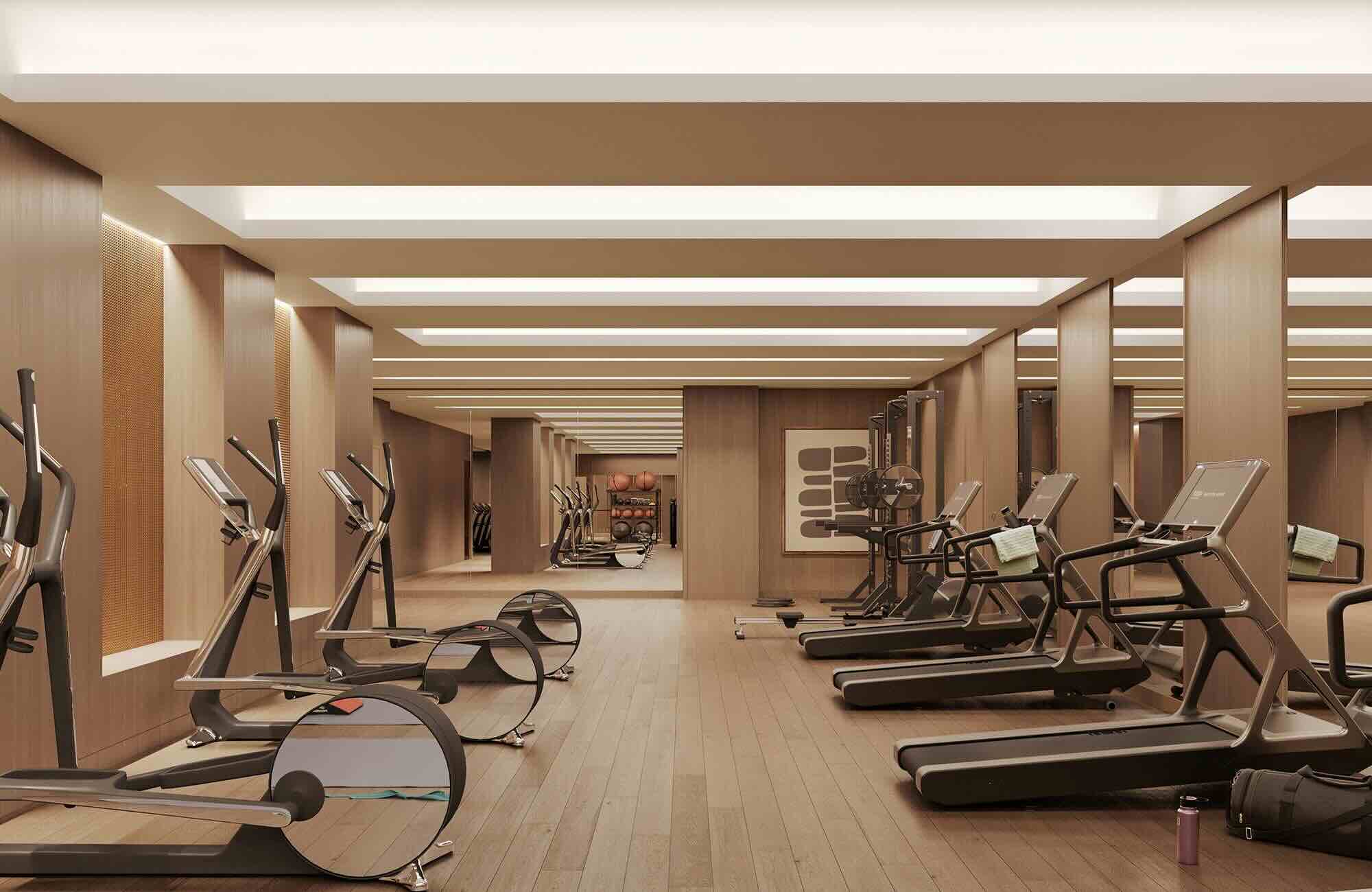 Modern luxury fitness center with wood-paneled walls and ceiling, featuring treadmills and elliptical machines with touchscreens, LED strip lighting, and mirrors in a spa-like design.
