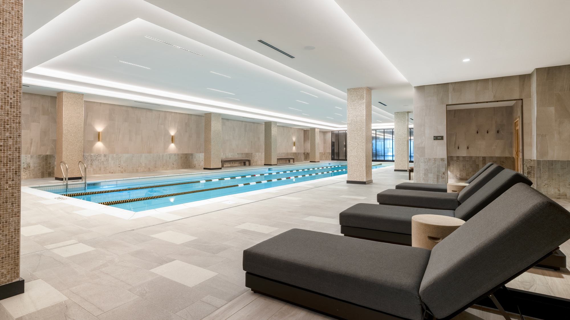 Indoor lap pool at Wardman Park in Washington, DC, featuring lane markers, tiled columns, and lounge chaises along the pool deck.