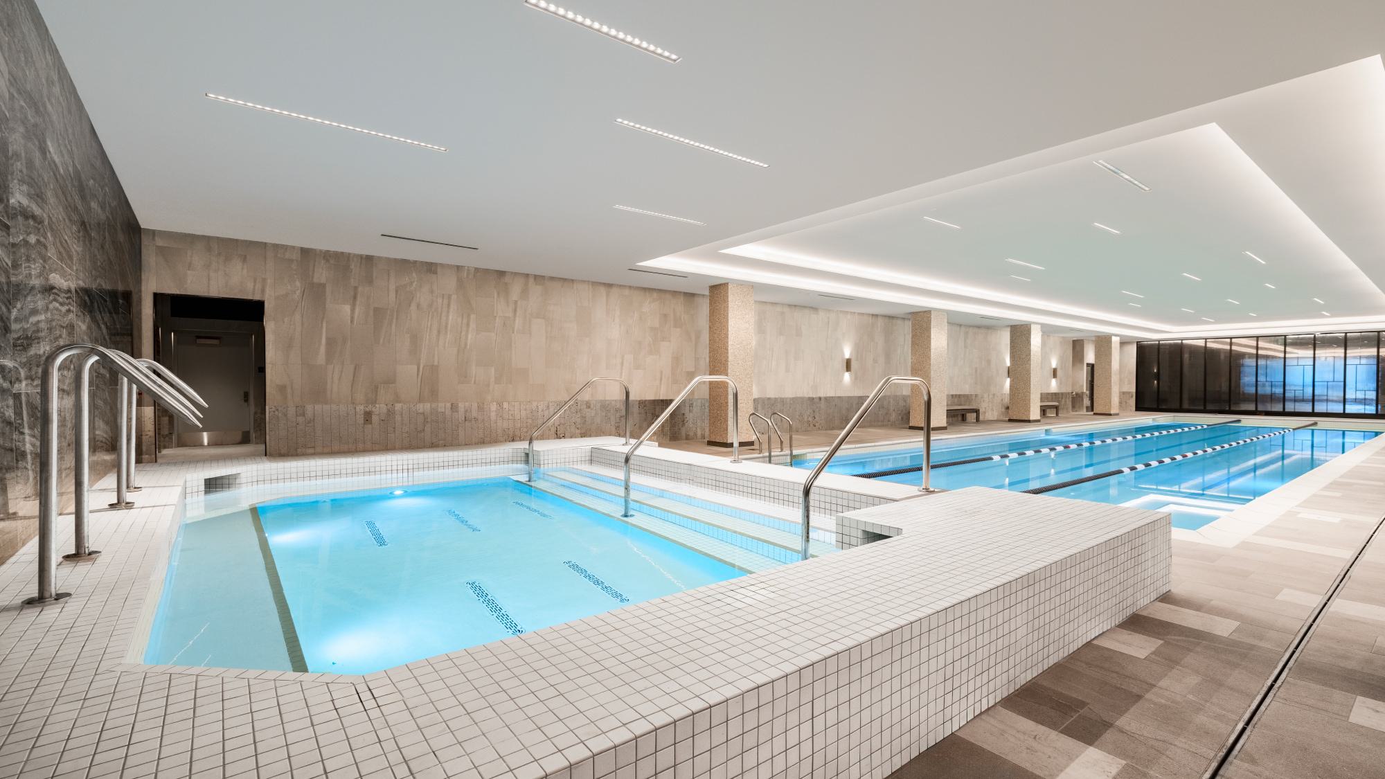 Indoor lap pool and spa at Wardman Park in Washington, DC, with tiled finishes, modern lighting, and relaxation areas.