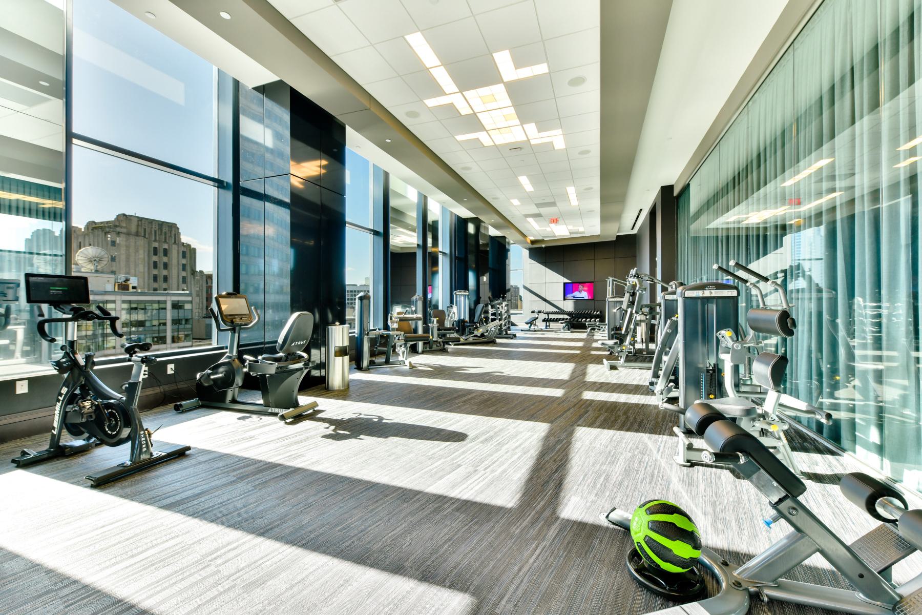 Functional training zone with a large blue rig outfitted for resistance work, boxing, and bodyweight exercises, surrounded by weights, ropes, and medicine balls.