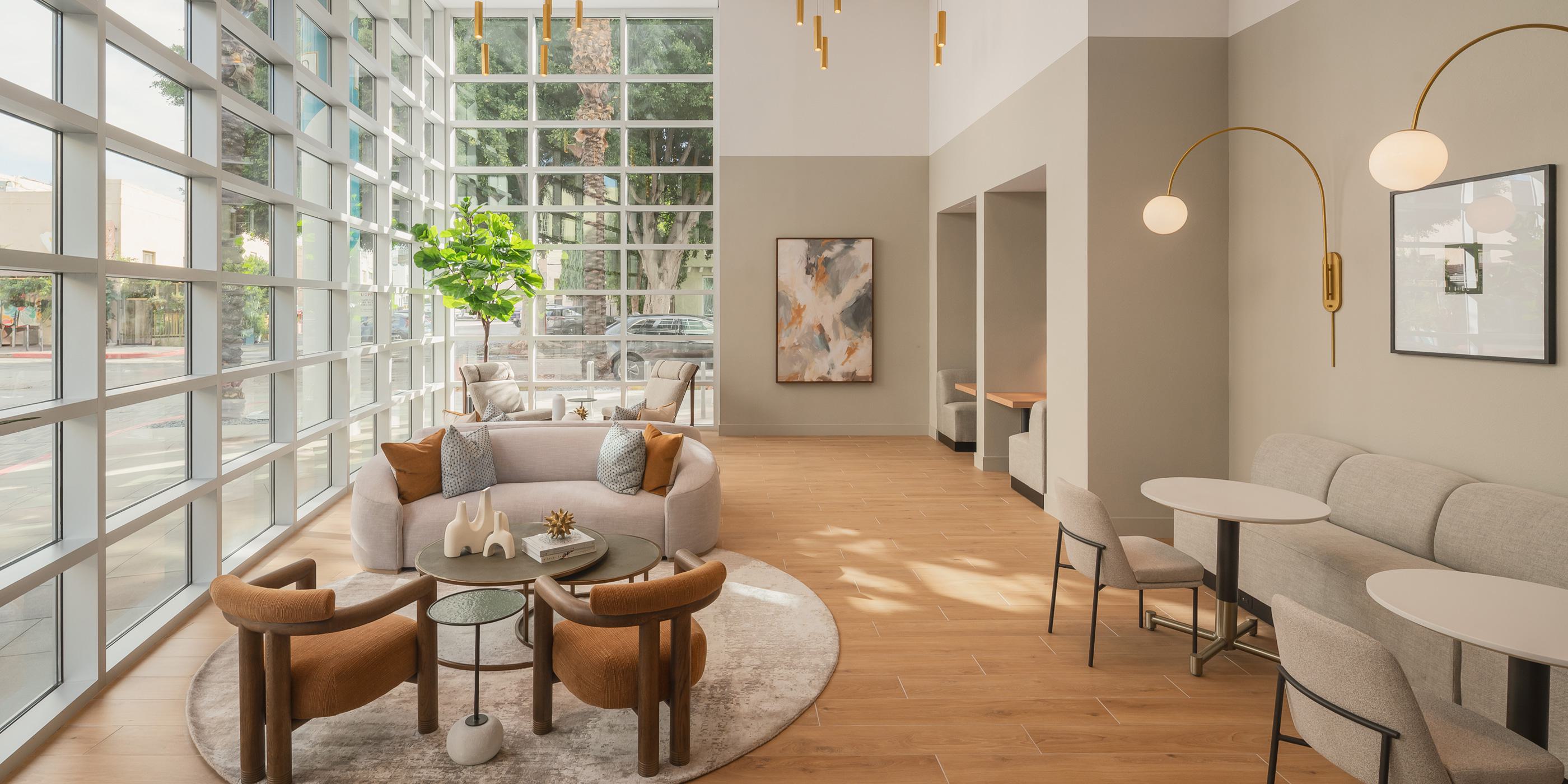 Modern apartment lobby with high ceilings, marble accents, statement lighting, and contemporary seating.