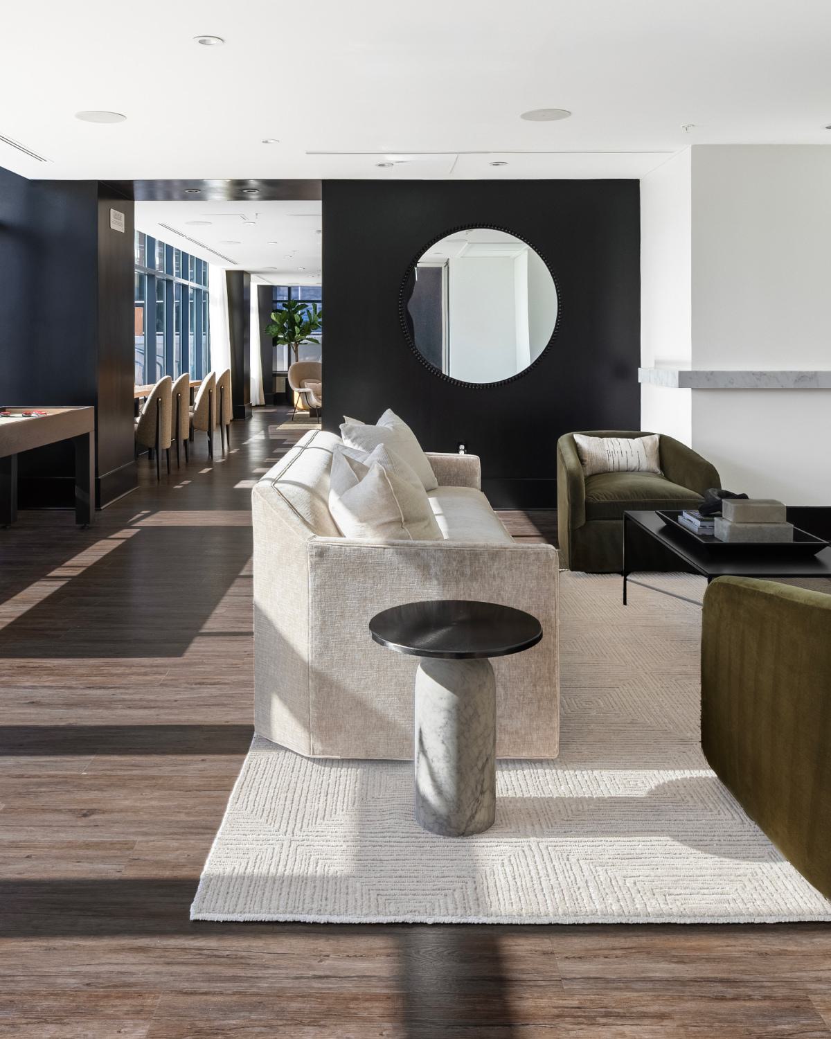 Resident lounge at Latitude Apartments in Virginia Square with contemporary seating, shuffleboard table, wall-mounted TV, and expansive windows providing natural light.