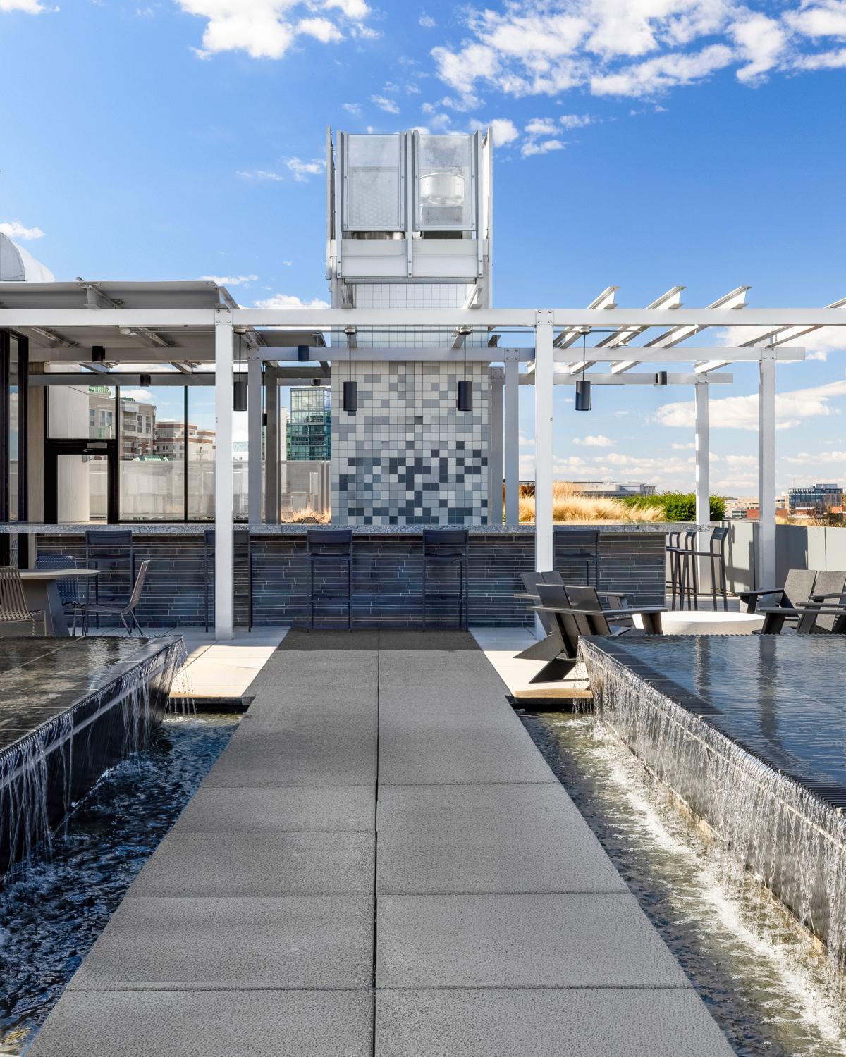 Rooftop water feature at Latitude Apartments in Virginia Square with reflecting pools, cascading edges, pergola seating, and open views across the surrounding neighborhood.