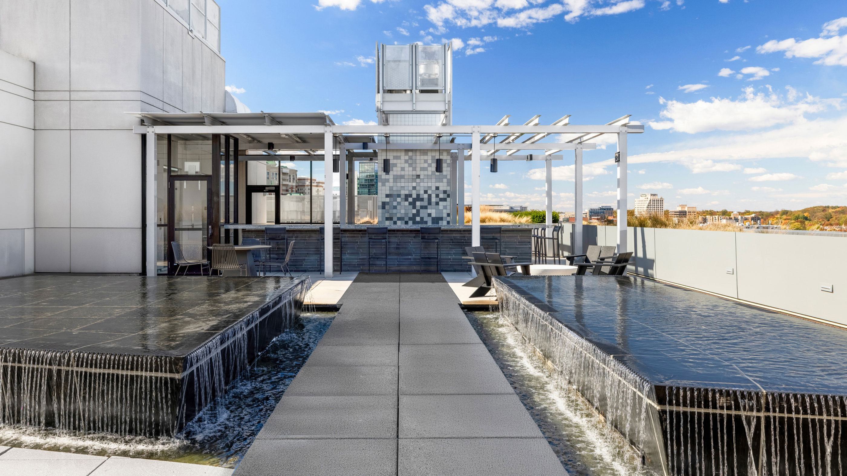Rooftop water feature at Latitude Apartments in Virginia Square with reflecting pools, cascading edges, pergola seating, and open views across the surrounding neighborhood.