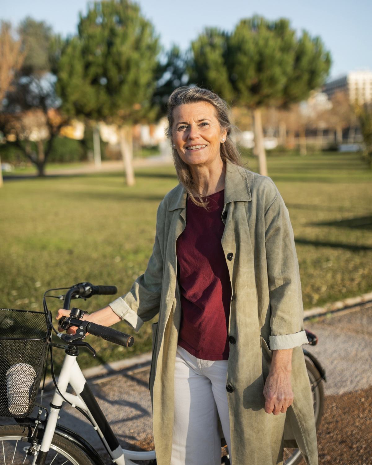 Resident walking a bike through a neighborhood park, representing access to nearby green spaces and tree-lined trails around Latitude Apartments in Arlington, Virginia.