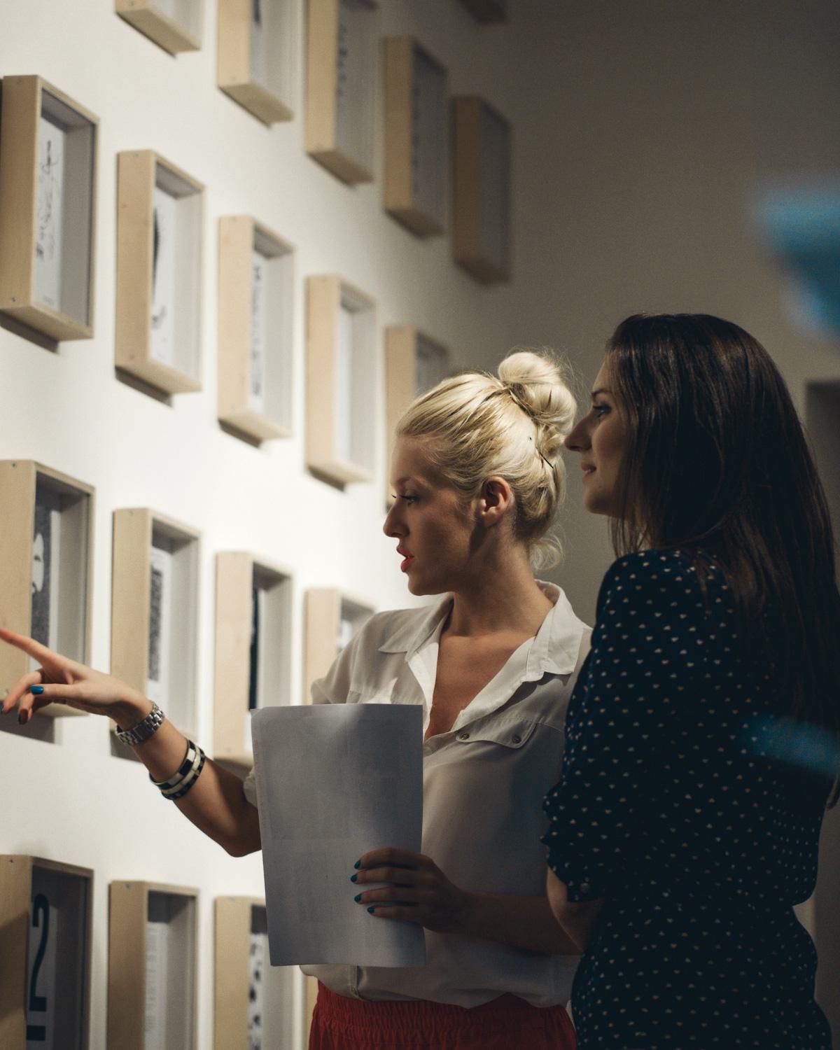 Visitors viewing artwork in a small gallery setting, representing nearby museums, galleries, and cultural destinations close to Latitude Apartments in Arlington, Virginia.