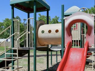 close up of a colorful playground structure with elevated walkways and slides at the arbors antelope