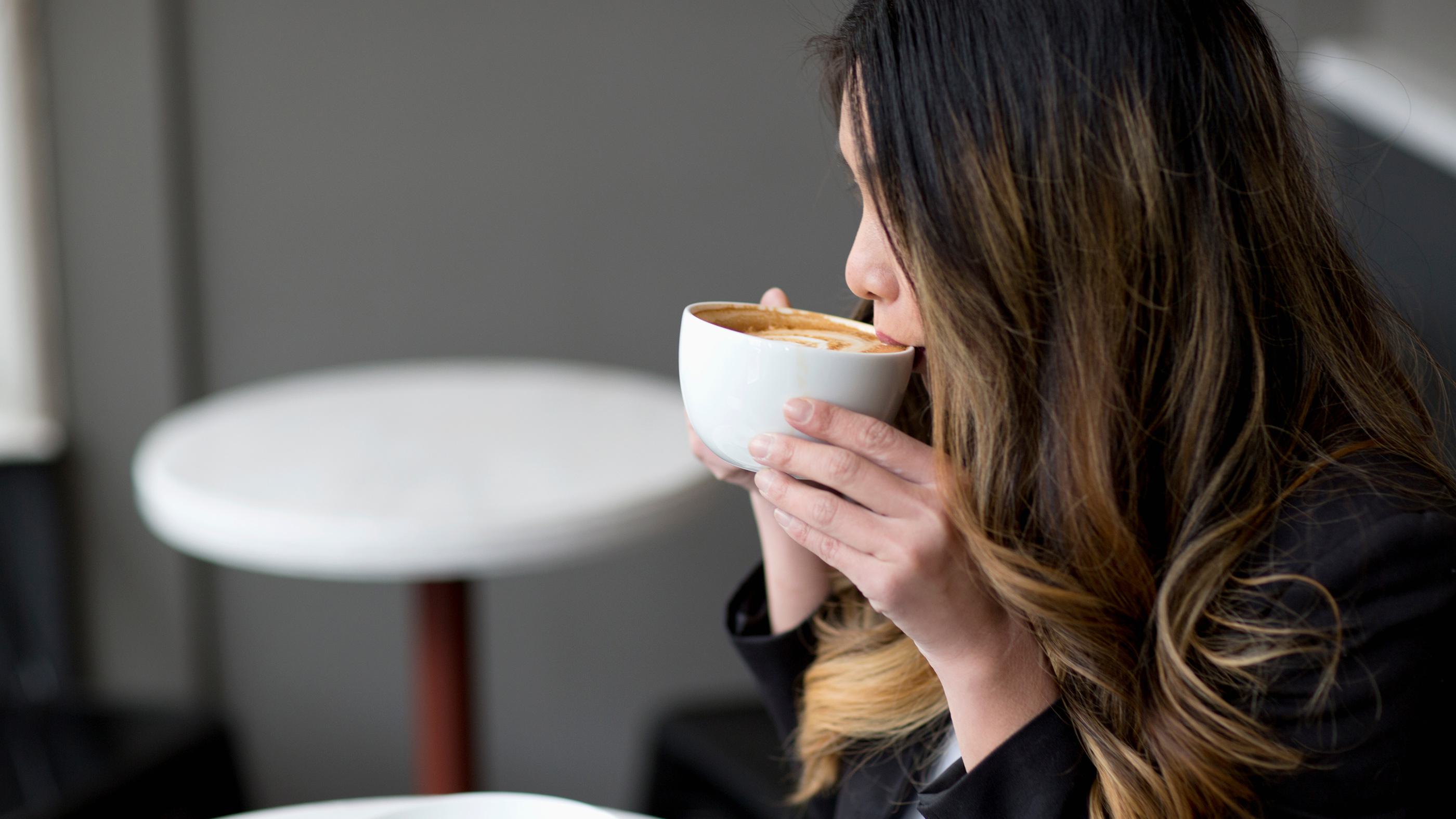 Woman drinking coffee in co-working space