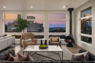 The Victor’s Sky Lounge with skyline views, modern fireplace, marble bar with navy cabinetry and gold lighting, and stylish lounge seating overlooking Seattle.