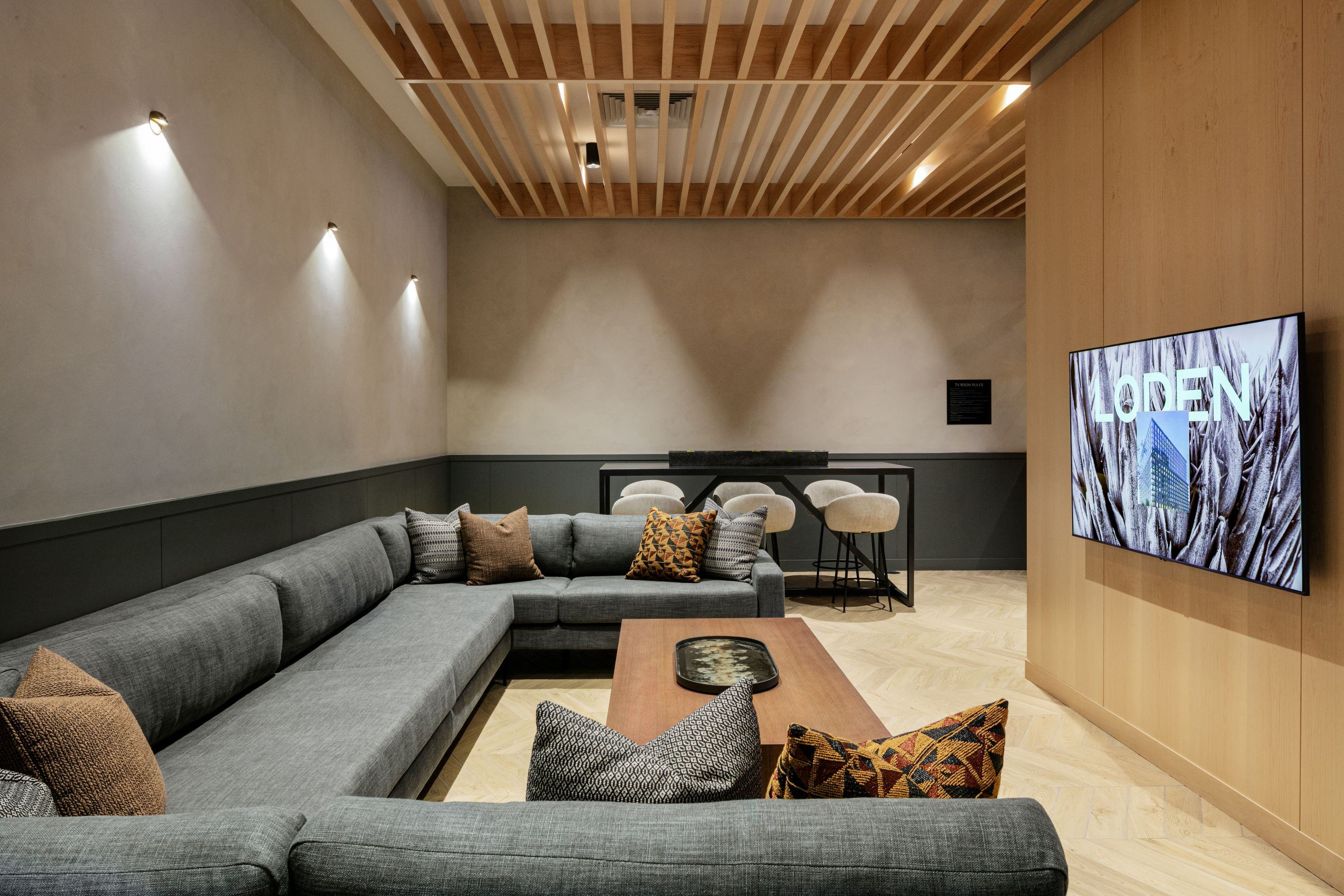 mounted TV set into a light wood paneled wall.