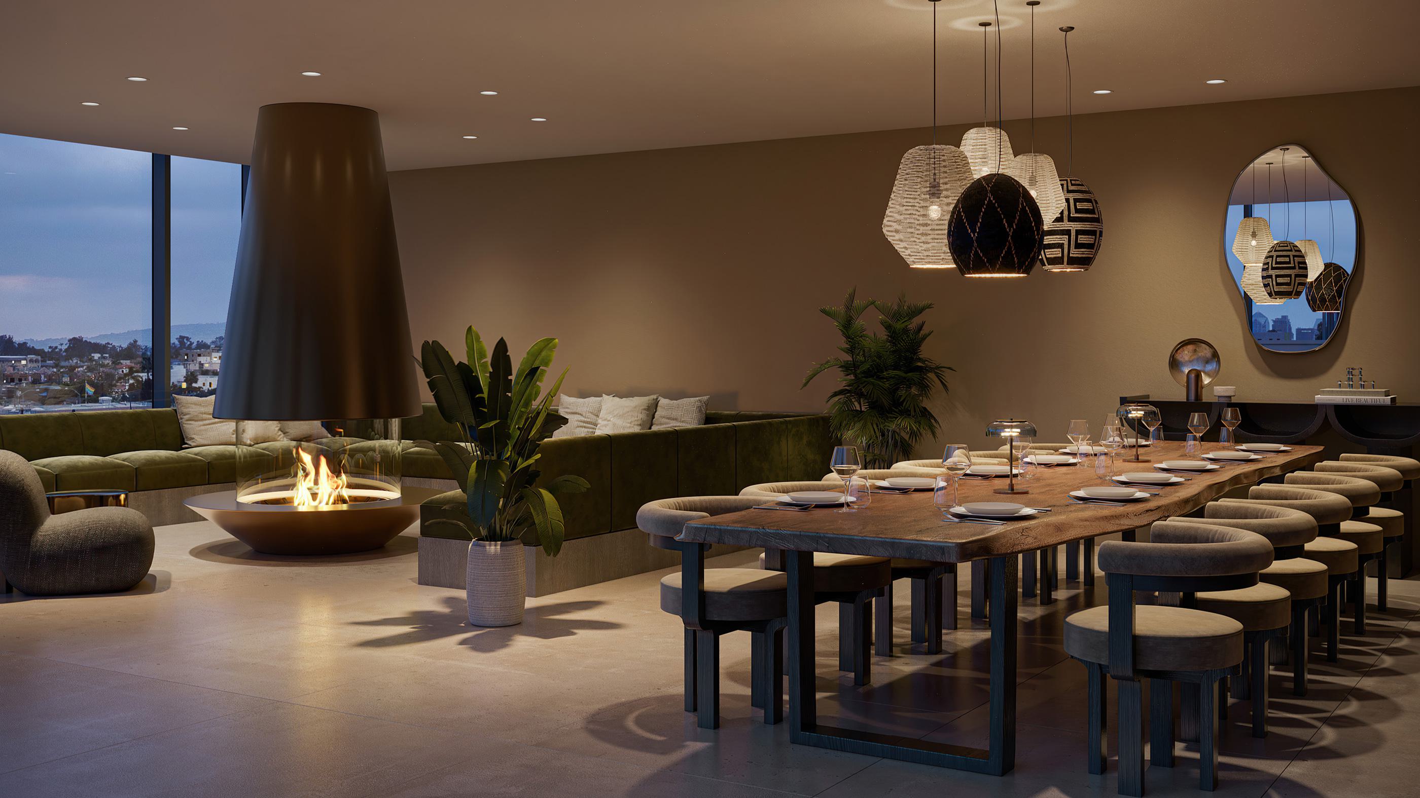 Indoor rooftop lounge at Rowyn featuring a suspended circular fireplace, velvet sectional seating, floor-to-ceiling windows with Hillcrest and San Diego skyline views, and a long communal dining table with sculptural pendant lighting.
