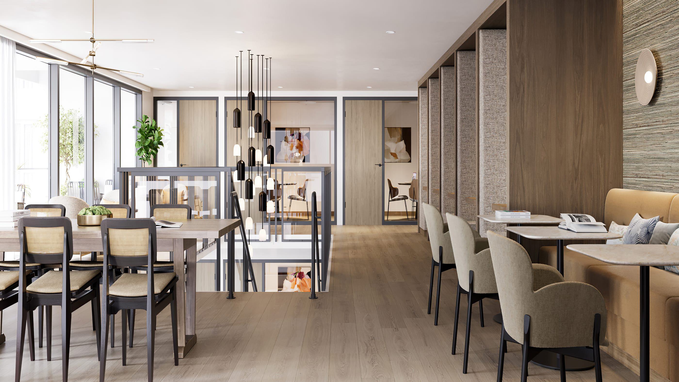 Two-story coworking space at Rowyn with floor-to-ceiling windows, communal tables, café seating, pendant lighting, and private glass-front conference rooms.