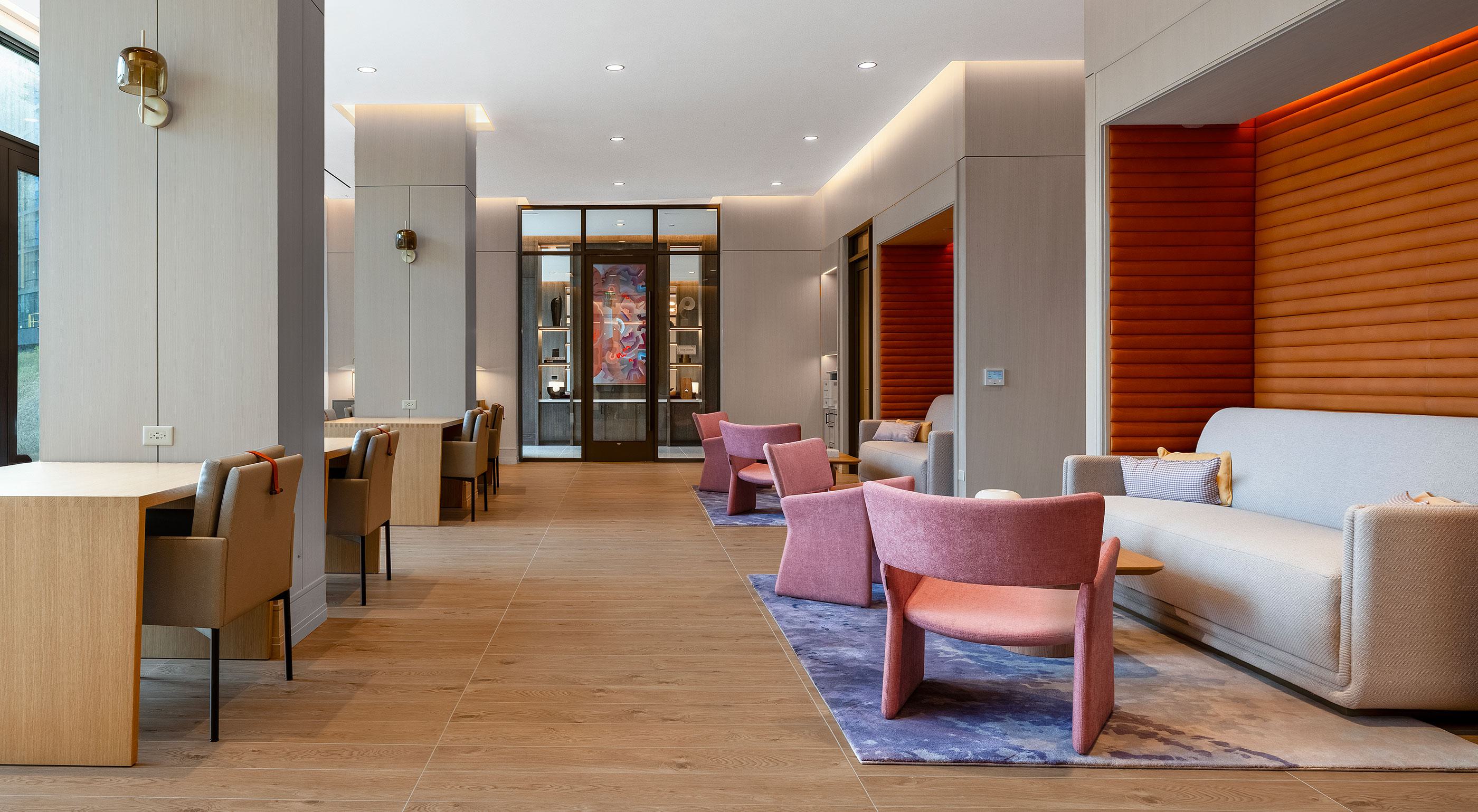 Coworking lounge at Aerie with tall ceilings, large windows, lounge seating, long workbar, and glass-door conference rooms.