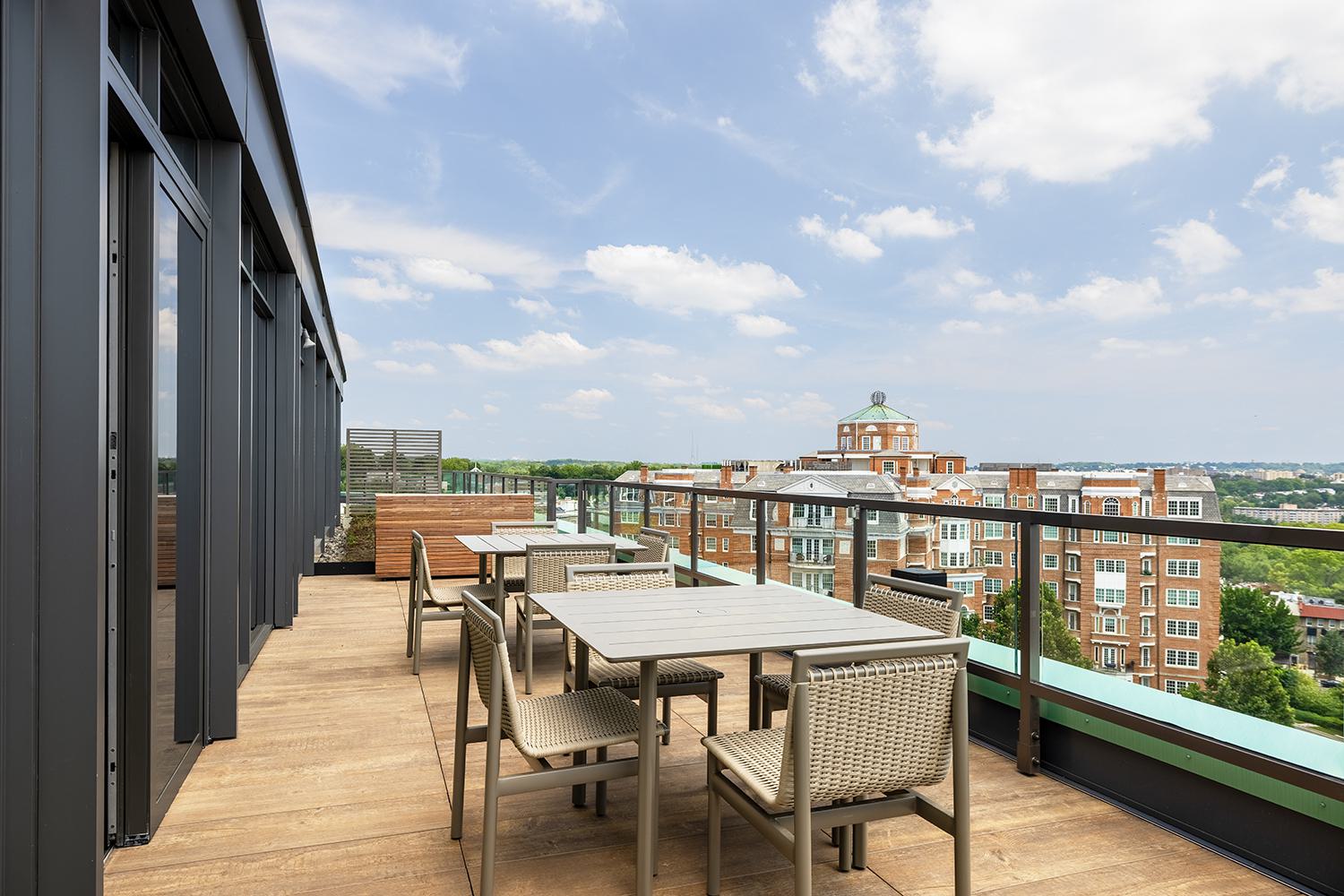 Outdoor seating area on Aerie’s observation deck with tables, woven chairs, and sweeping views over Woodley Park from one of DC’s higher elevations.