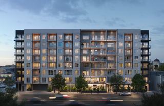 A modern mid-rise apartment building in Hillcrest with a grid of large windows and private balconies, softly lit at dusk, overlooking Sixth Avenue.