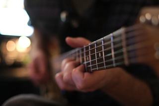 close up of a someone playing an acoustic guitar