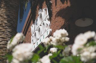 close up of Whole Foods sign with blossoming trees