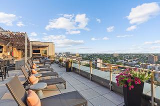 Rooftop Sky Deck at Vela in downtown Stamford with lounge chairs, pergola seating, and panoramic city and Long Island Sound views