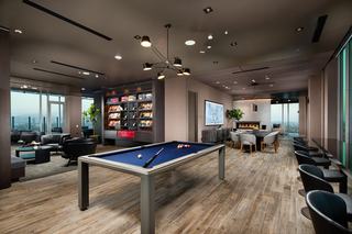 ARQ’s 31st-floor Sky Lounge with pool table, fireplace dining area, DJ library wall, and floor-to-ceiling windows overlooking Los Angeles