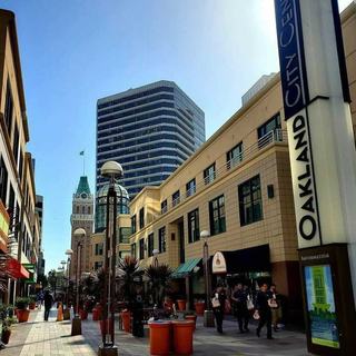 Pedestrian walkway at Oakland City Center with shops, offices, and the Tribune Tower in the background