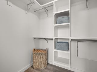 Walk-in closet at Atlas featuring open shelving, double hanging rods, and storage space