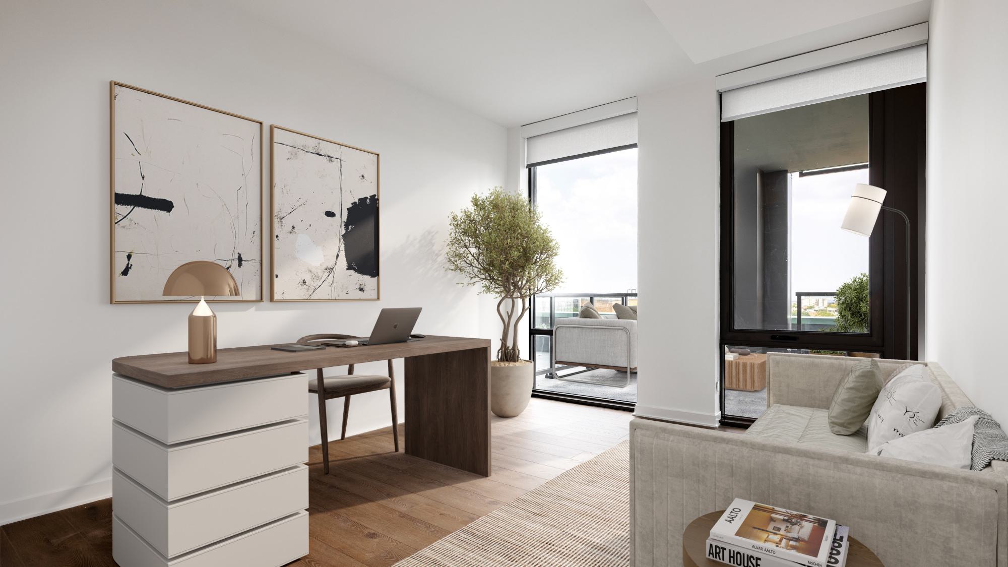 Home office at Aerie with a wood desk and drawer base, large window and balcony access, modern art, and a lounge sofa in a bright, flexible den space.