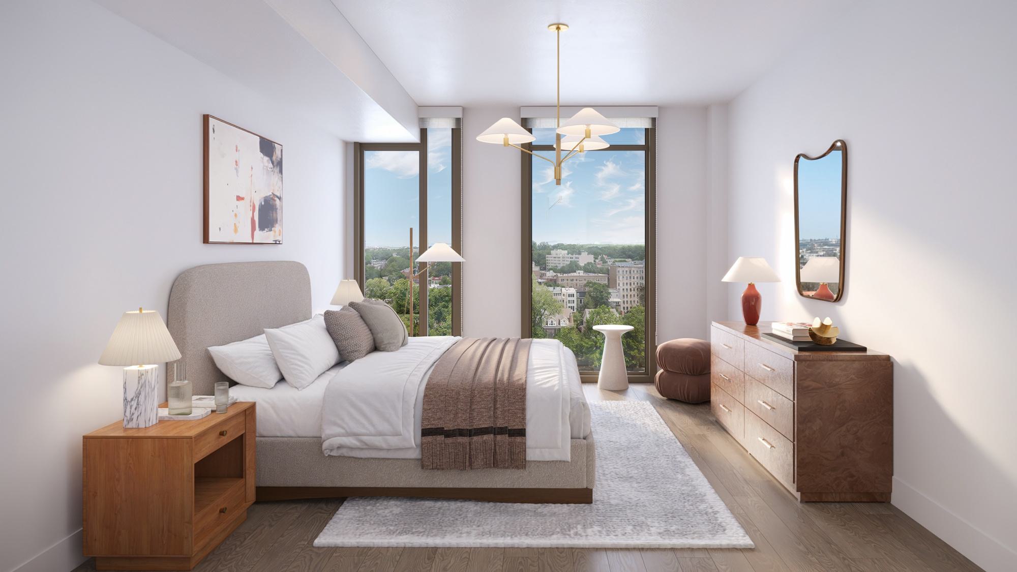 Penthouse primary bedroom with expansive windows, treetop views, high ceilings, warm wood flooring, and refined modern furnishings.