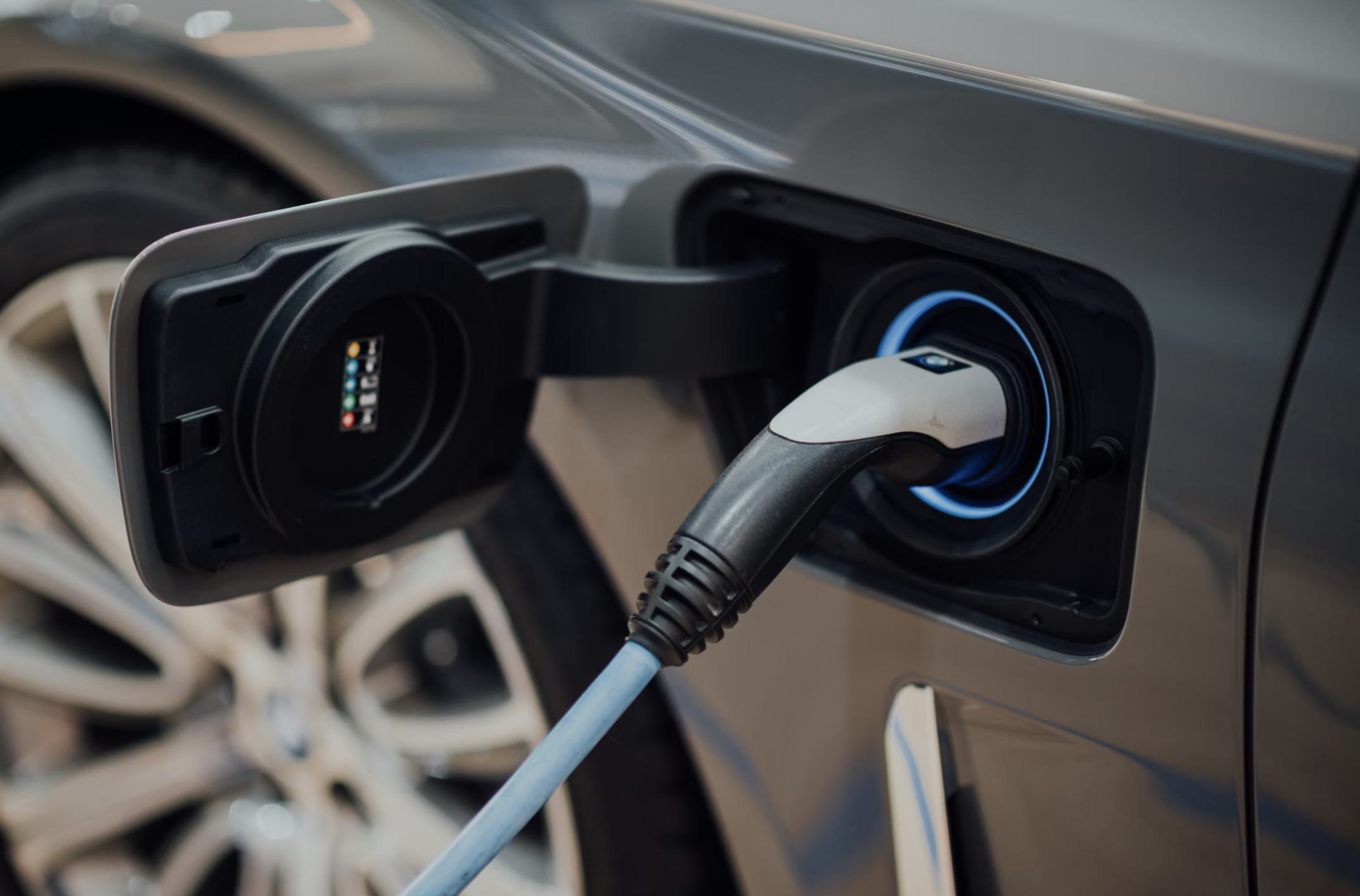 Electric vehicle plugged into on-site EV charging station in Aerie’s resident parking garage, with illuminated charging port and cable connected.
