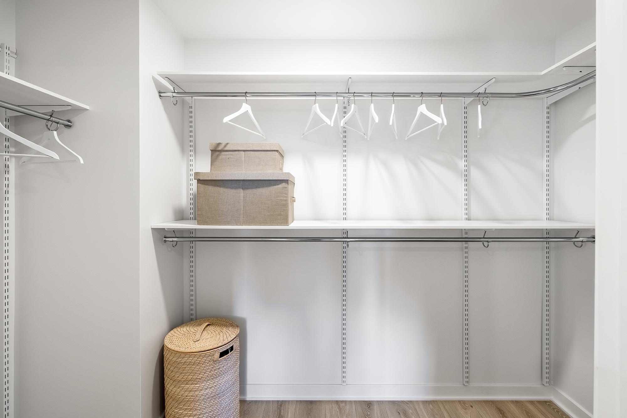 Modular walk-in closet at Zephyr with adjustable shelving, dual hanging rods, and open upper storage.