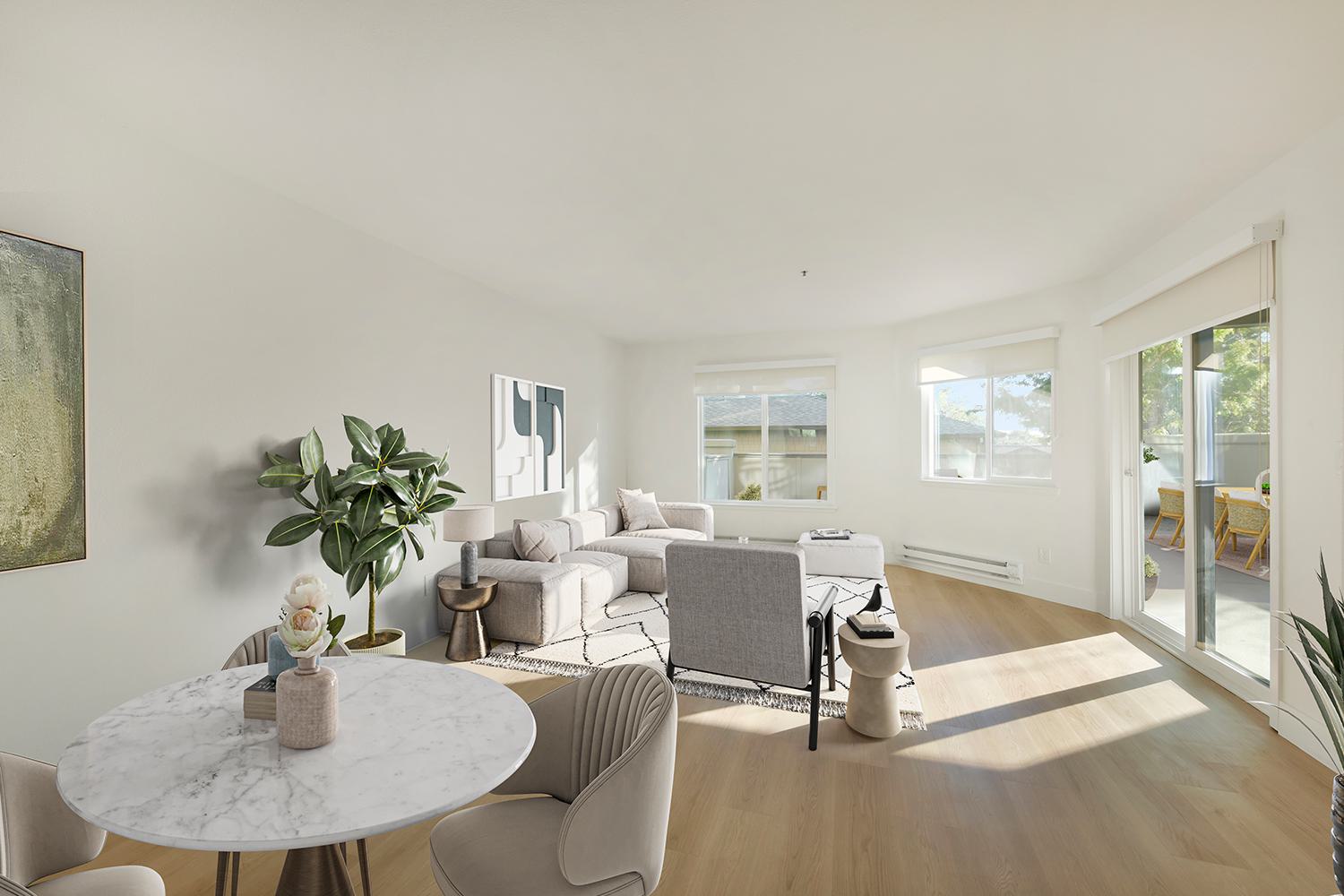 Open, bright living room with table and couch looking outside