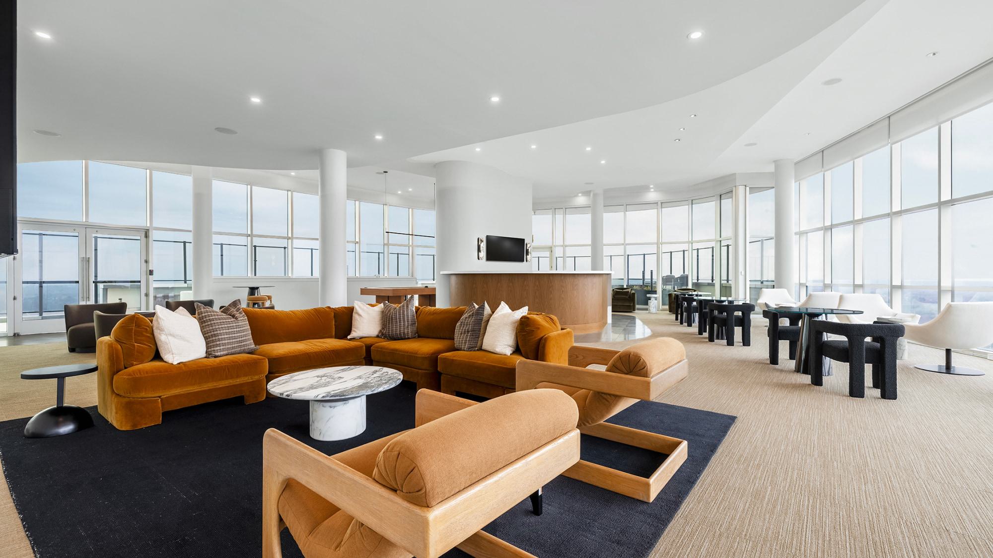 Window-lined café tables and lounge seating in Adaire’s 35th-floor sky lounge with expansive panoramic views over Tysons and the Blue Ridge foothills.