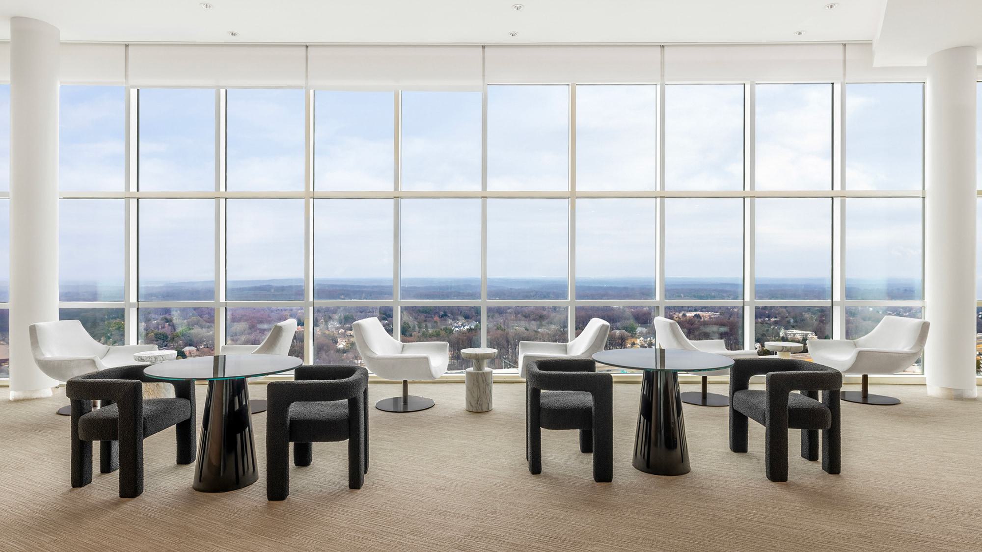 35th-floor sky lounge at Adaire featuring sculptural seating, marble coffee table, curved bar, and floor-to-ceiling glass with sweeping skyline views.